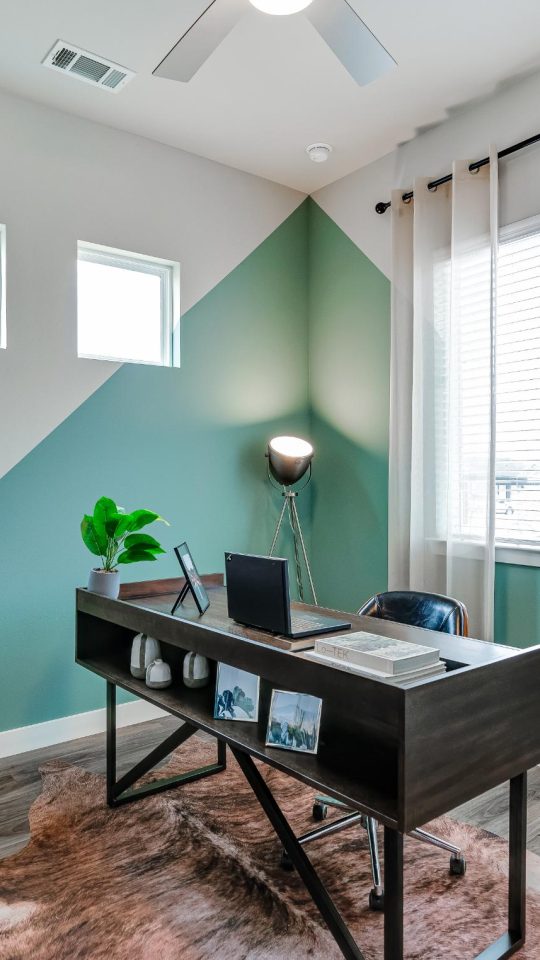 a home office with a desk and a fan at The VLux Stoneridge
